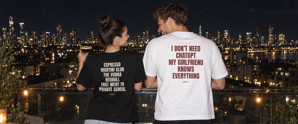 Mara and Theo at a rooftop bar at night in SBTXT tees